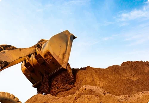 Heavy machine moving soil on an excavation site