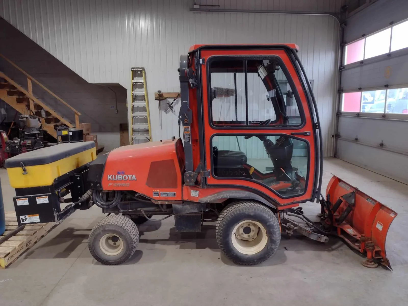 Sidewalk tractor fitted with snow-removal equipment